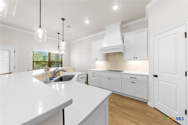 8917 Sassafras St, Temple, TX 76502 - kitchen with a sink, custom exhaust hood, black electric stovetop, light countertops, and tasteful backsplash
