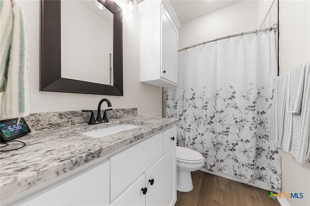 8917 Sassafras St, Temple, TX 76502 - bathroom featuring wood finished floors, toilet, vanity, and a shower with shower curtain