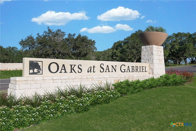 community / neighborhood sign with a lawn