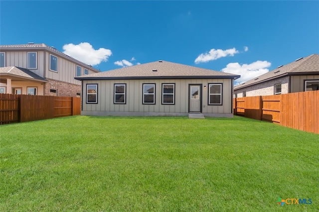 rear view of property with a lawn