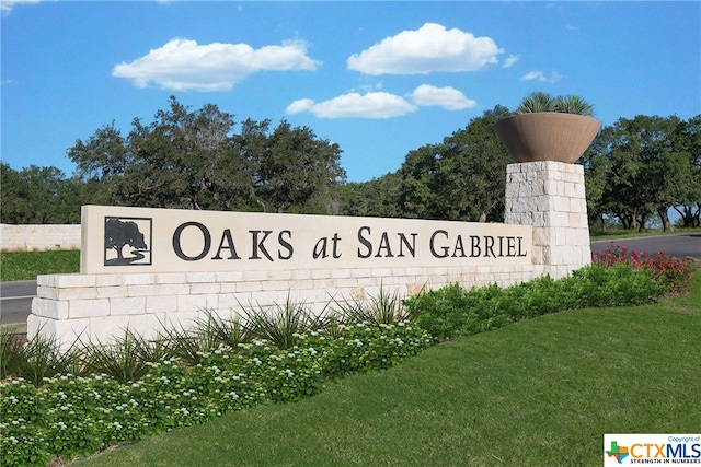 community / neighborhood sign featuring a lawn