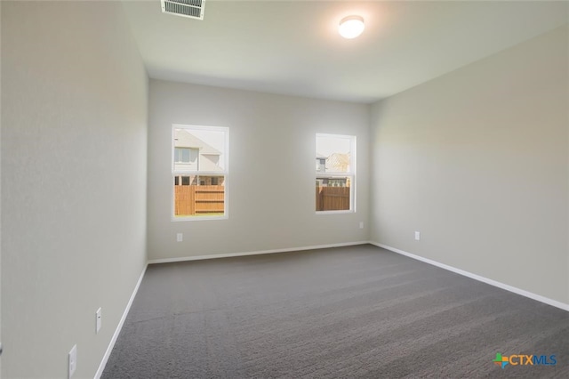 carpeted spare room featuring plenty of natural light