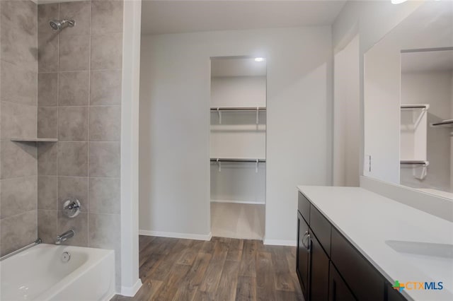 bathroom featuring hardwood / wood-style floors, vanity, and tiled shower / bath