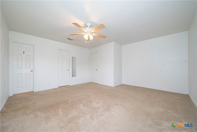 carpeted empty room featuring ceiling fan and a textured ceiling