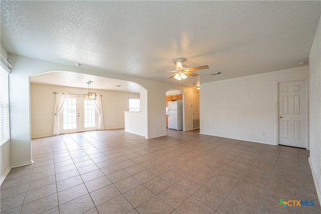 tiled spare room featuring a textured ceiling and ceiling fan