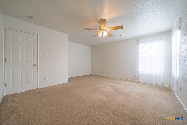 carpeted empty room with ceiling fan and a textured ceiling