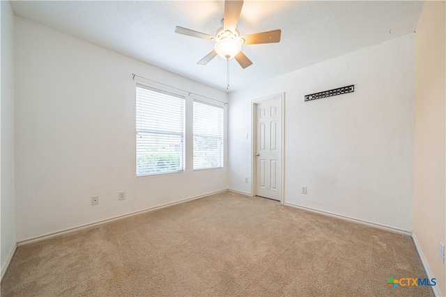 unfurnished room with ceiling fan and light carpet