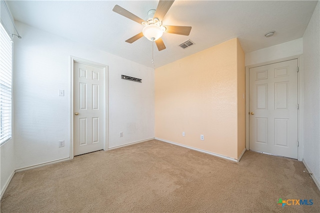 unfurnished bedroom with light colored carpet and ceiling fan