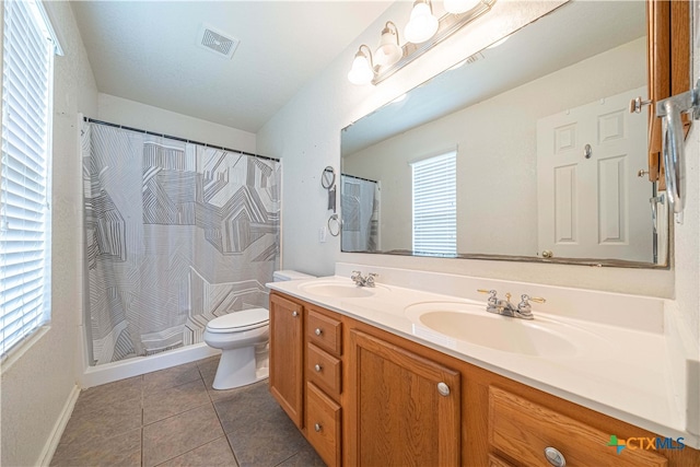 bathroom featuring tile patterned flooring, curtained shower, vanity, and toilet