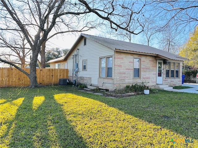 view of front of property featuring central AC unit and a front lawn