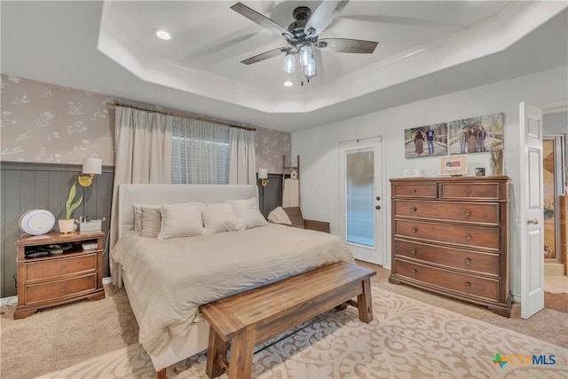 bedroom with wallpapered walls, a tray ceiling, recessed lighting, and light colored carpet