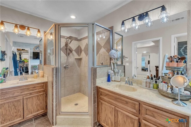 bathroom featuring tile patterned floors, visible vents, vanity, and a stall shower