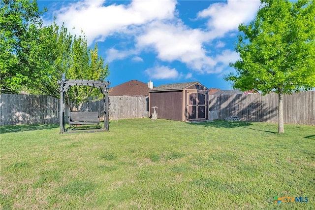view of yard with an outdoor structure, a storage unit, and a fenced backyard