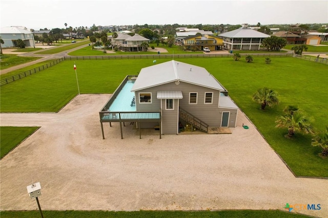 1007 N Washington Blvd, Port Oconnor, TX 77982 - rear view of house featuring a residential view, a lawn, and stairway
