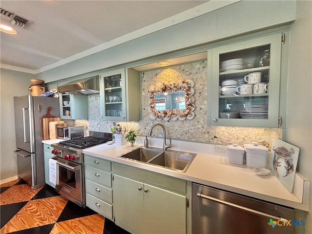 1007 N Washington Blvd, Port Oconnor, TX 77982 - kitchen with stainless steel appliances, a sink, light countertops, wall chimney range hood, and glass insert cabinets
