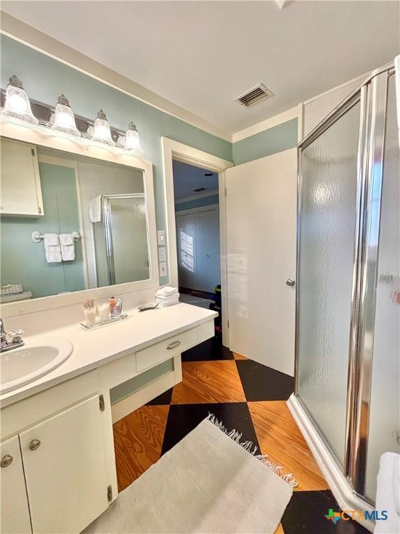 1007 N Washington Blvd, Port Oconnor, TX 77982 - full bathroom with a shower stall, vanity, and wood finished floors