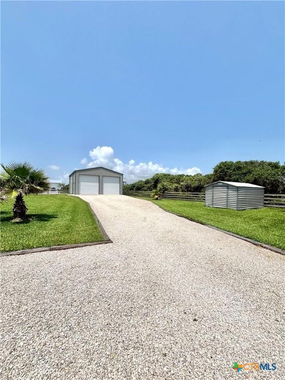 1007 N Washington Blvd, Port Oconnor, TX 77982 - view of property exterior featuring a detached garage and an outdoor structure