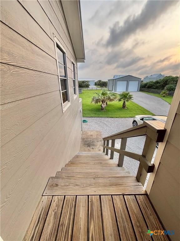 1007 N Washington Blvd, Port Oconnor, TX 77982 - wooden deck featuring an outbuilding, a detached garage, and a yard