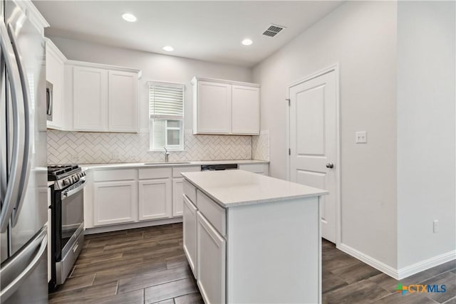 310 Spiny Lizard Ln, San Marcos, TX 78666 - kitchen featuring appliances with stainless steel finishes, decorative backsplash, a sink, dark wood-style floors, and recessed lighting