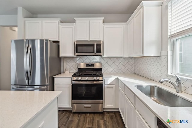 310 Spiny Lizard Ln, San Marcos, TX 78666 - kitchen with appliances with stainless steel finishes, a sink, white cabinetry, and dark wood-style floors