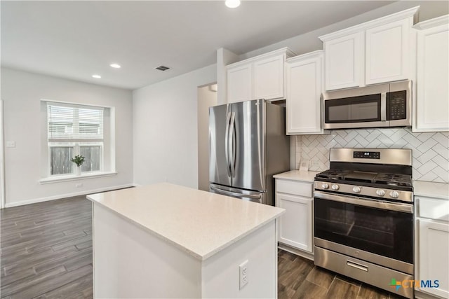 310 Spiny Lizard Ln, San Marcos, TX 78666 - kitchen with stainless steel appliances, recessed lighting, dark wood-type flooring, tasteful backsplash, and light countertops