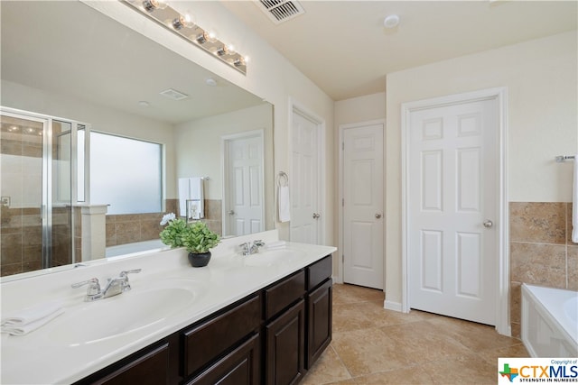 bathroom with tile patterned flooring, vanity, and shower with separate bathtub