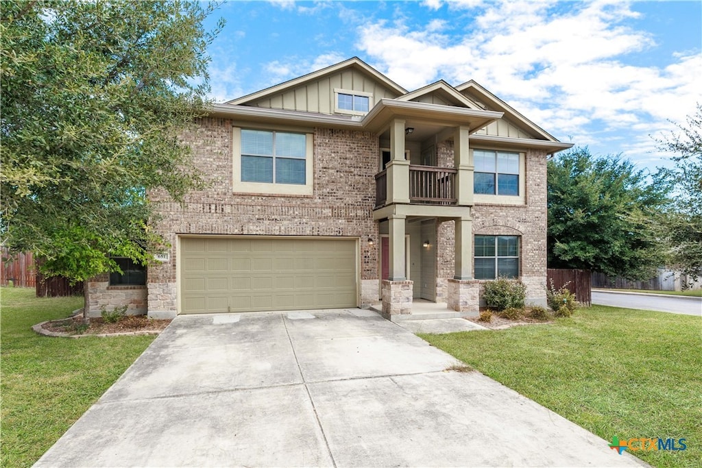 craftsman-style home with a front yard, a balcony, and a garage