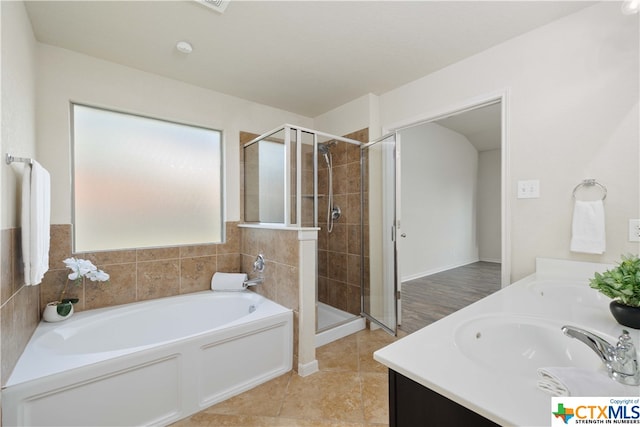 bathroom with tile patterned floors, vanity, and shower with separate bathtub