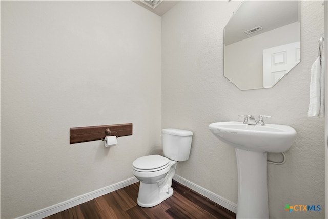 bathroom featuring toilet, wood-type flooring, and sink