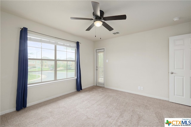 carpeted spare room with ceiling fan