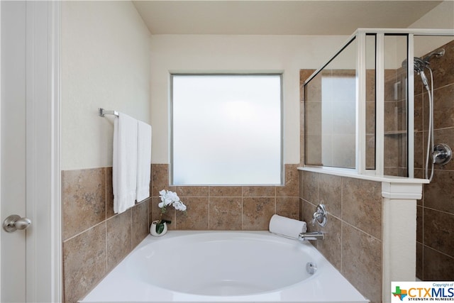 bathroom featuring independent shower and bath