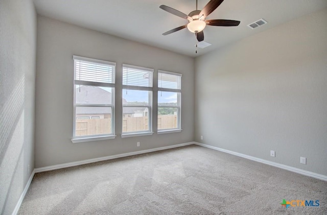 carpeted spare room with ceiling fan