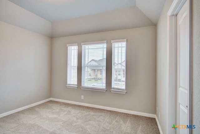 carpeted spare room with lofted ceiling