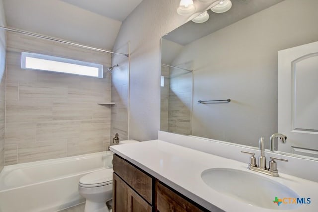 full bathroom with toilet, vanity, vaulted ceiling, and tiled shower / bath