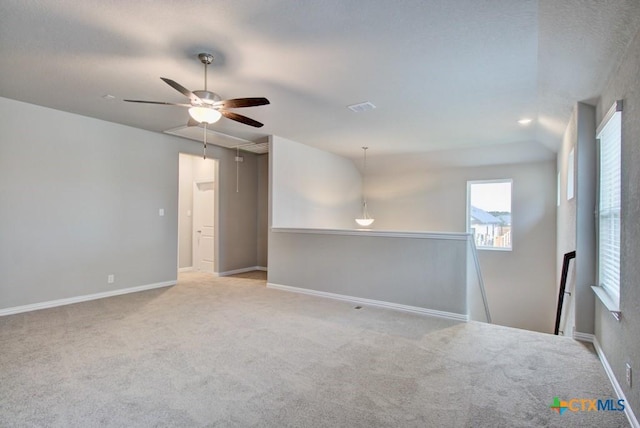 empty room with ceiling fan, lofted ceiling, and light carpet