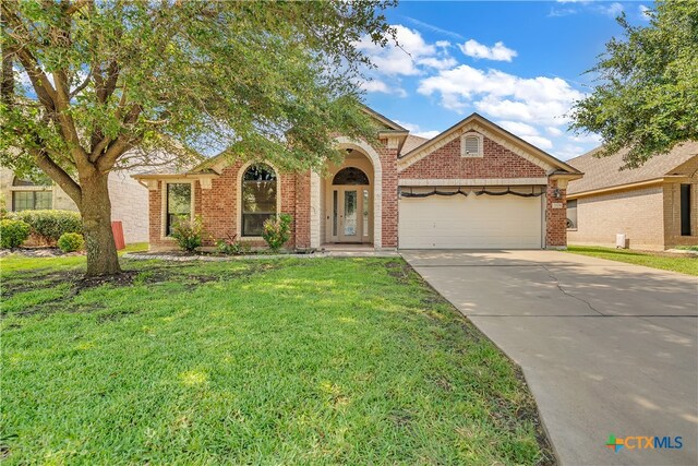 view of front of home with a front yard and a garage