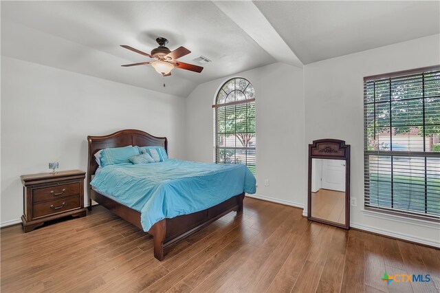 bedroom with hardwood / wood-style floors, ceiling fan, and vaulted ceiling