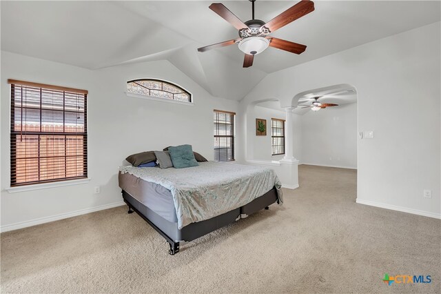 bedroom featuring ceiling fan, ornate columns, lofted ceiling, and light colored carpet