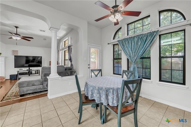 dining space featuring decorative columns and light tile patterned floors