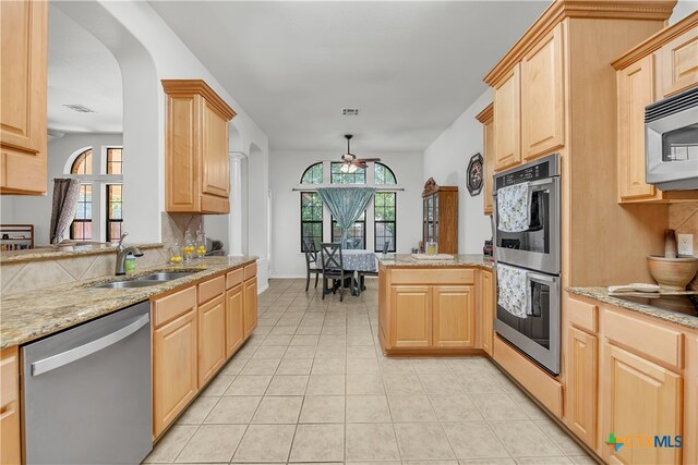 kitchen featuring light brown cabinets, appliances with stainless steel finishes, sink, and ceiling fan