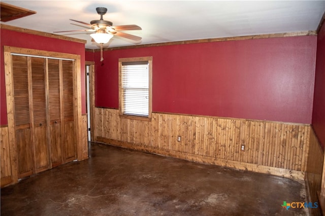 203 S Gisler St, Austwell, TX 77950 - unfurnished bedroom with a closet, ceiling fan, and wood walls