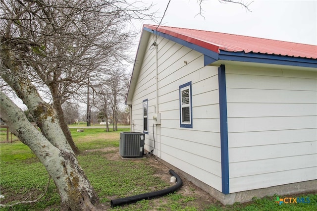 203 S Gisler St, Austwell, TX 77950 - view of home's exterior with central AC and a lawn