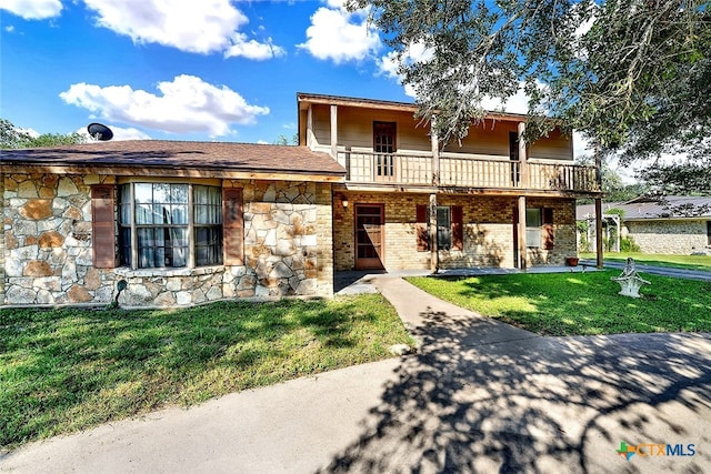 view of front of house featuring a front yard and a balcony