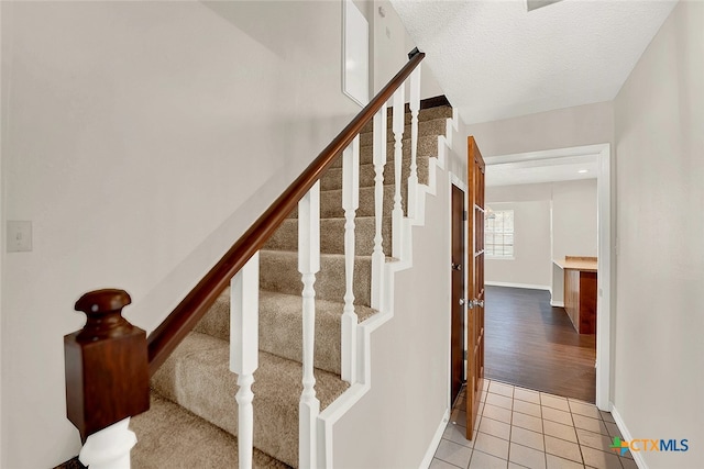 stairs featuring hardwood / wood-style flooring and a textured ceiling