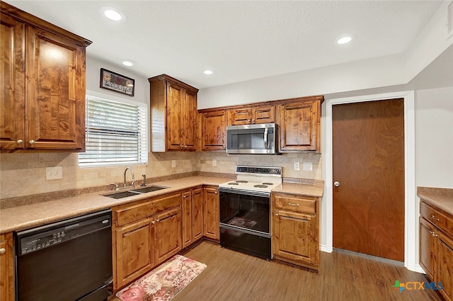 kitchen with sink, light wood-type flooring, dishwasher, and electric range