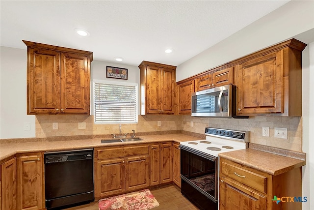 kitchen with sink, electric stove, light hardwood / wood-style flooring, decorative backsplash, and black dishwasher