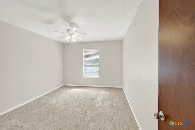 carpeted spare room featuring a textured ceiling and ceiling fan