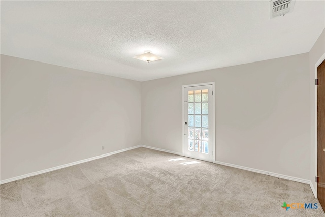 carpeted spare room with a textured ceiling