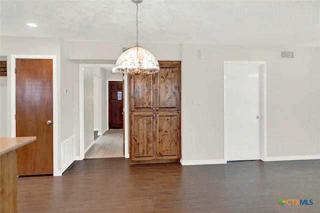 unfurnished dining area featuring dark hardwood / wood-style flooring and a chandelier