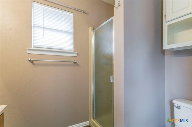 full bathroom featuring a shower stall and toilet